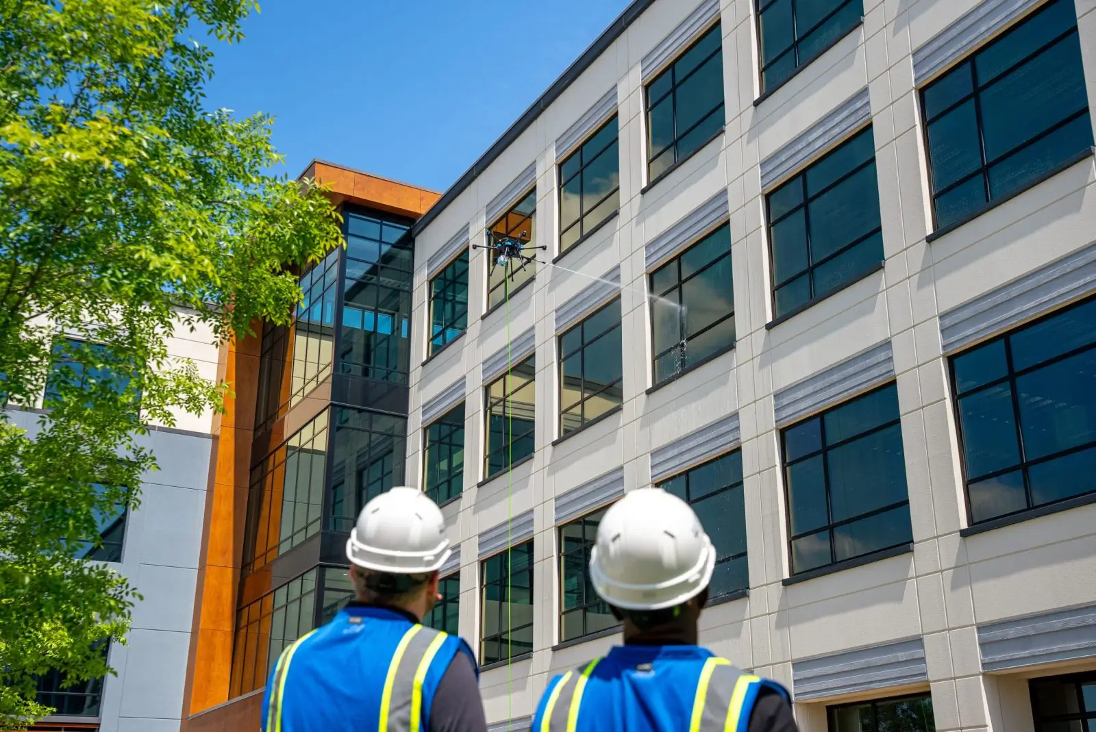Two construction workers inspecting a modern building exterior.